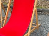 a red chair that is sitting in the gravel