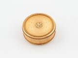 a gold plated box with a circular design on the lid