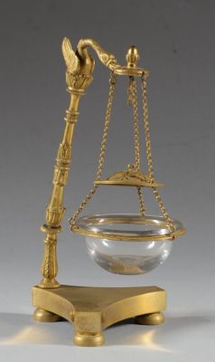 une image représentant une balance en or sur laquelle est posé un bol en verre