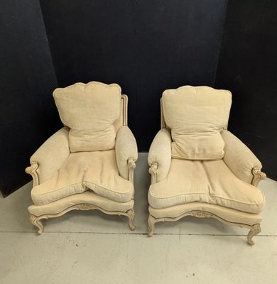 pair of antique french style lounge chairs with upholstered cushions