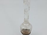 a glass vase with a silver base on a table