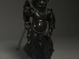 bronze figure of a man holding a sword and a bird