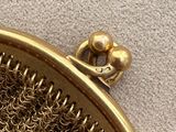 a gold purse that has a chainmail inside of it
