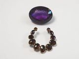 a close up of a pair of earrings with a purple stone