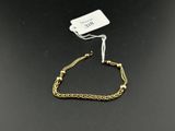 un bracelet en chaîne d'or auquel est attachée une plaque