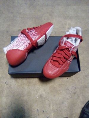 une paire de chaussures rouges et blanches posée sur une boîte