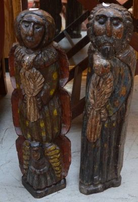 deux statues en bois représentant des personnes debout côte à côte