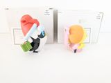two figurines of a penguin and a penguin in a box