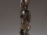 a wooden statue of a woman holding a baby