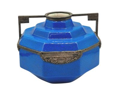 a blue vase with a metal handle on a white background