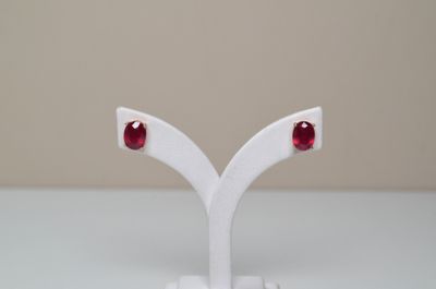 une paire de boucles d'oreilles posée sur un présentoir blanc