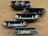 four different types of train cars sitting on the ground