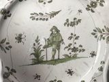 a green and white plate with a picture of a man on it