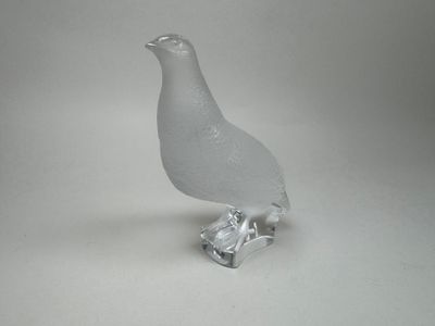 un oiseau en verre posé sur un morceau de verre