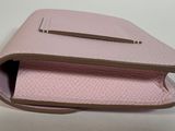 pink leather case for a cell phone on a white surface