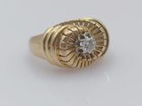 gros plan d'une bague en or avec un diamant au centre