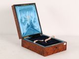 a small wooden box with a ring inside of it