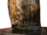 sculpture of a man ' s head on a pedestal with a white background