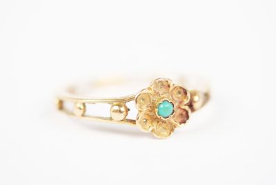 a close up of a gold ring with a turquoise stone