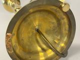 a small brass object on a white surface