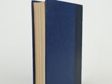 a close up of a book on a white surface with a blue cover