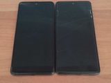 two black iphones sitting side by side on a wooden table
