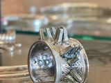 une bague en argent posée sur une table en verre
