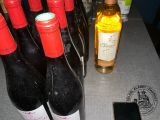 several bottles of wine are lined up on a table next to a cell phone
