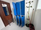 a blue locker in a room with a broom and a mirror