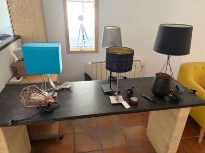 un bureau sur lequel se trouvent une lampe, un abat-jour et d'autres objets
