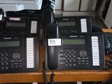 five telephones sitting on a table with a price tag on them