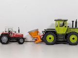 many toy tractors lined up in a row on a white surface