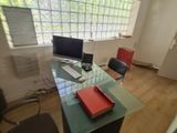a glass desk with a computer and a laptop on it