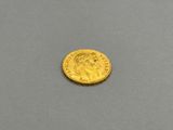 a close up of a gold coin on a gray surface