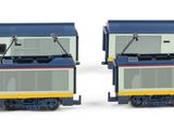 two model trains sitting side by side on a white surface