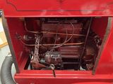 a red truck with a hose attached to it ' s side