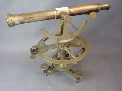 un vieux télescope en laiton posé sur un trépied, sur fond gris