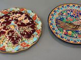 two decorative plates with birds on them on a table