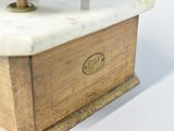 a white marble clock on a wooden stand on a white surface