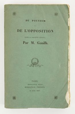 un vieux livre posé sur une table à côté d'un mur blanc