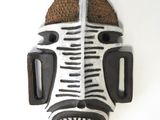 a zebra mask hanging on a wall on a white background