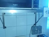 a microwave that is sitting on a shelf above a sink