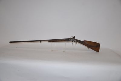 a rifle with a wooden barrel on a white surface