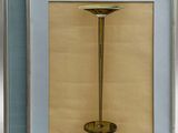 two framed pictures of a table with a lamp on top of it
