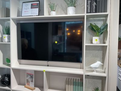 un téléviseur posé sur un meuble TV blanc dans un salon