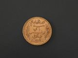 a close up of a gold coin on a black surface