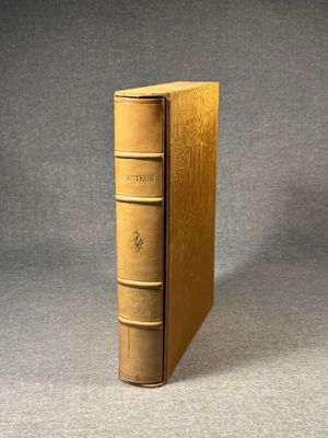 an old book sitting on top of a table next to a gray wall