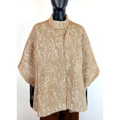 un gros plan sur un mannequin portant un pull doré