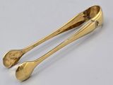 pair of gold plated spoons on a white background
