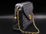a black purse with gold chain on a black background